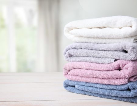 Colorful folded towels stack on table empty copy space.