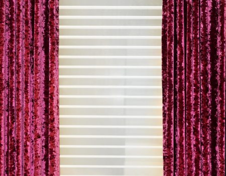 Detail of decorative red velvet curtains in home interior
